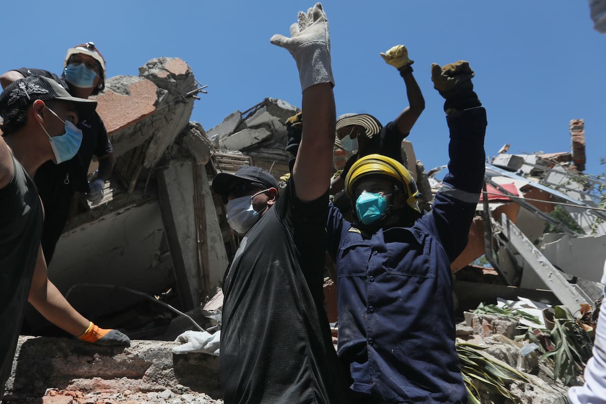 La gente pide silencio durante la búsqueda de supervivientes tras el terremoto que sacudió Cali, Col