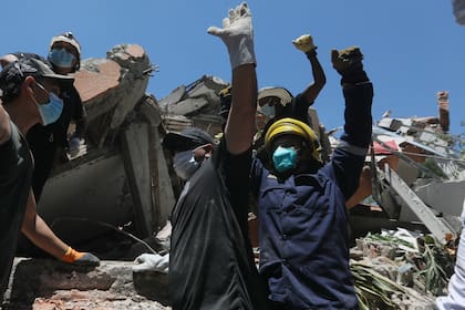 La gente pide silencio durante la búsqueda de supervivientes tras el terremoto que sacudió Cali