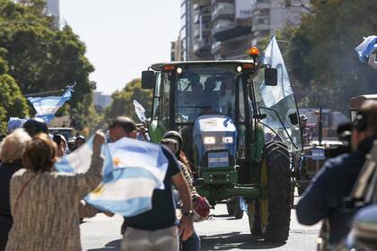 La gente recibe con bandera a los tractores de la marcha del campo