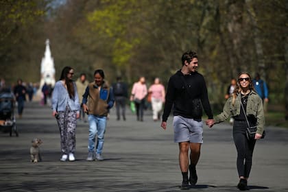 La gente sale a caminar en el clima cálido en Regent's Park en Londres el 29 de marzo de 2021, cuando se alivian las restricciones de bloqueo de Inglaterra, lo que permite que grupos de hasta seis personas se reúnan afuera