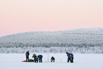 La gente sale a pescar en el hielo en Äkäslompolo, en el municipio de Kolari, en la Laponia finlandesa, el 4 de enero de 2024, durante unas condiciones de congelación extrema que persistirán durante toda la semana en toda Finlandia. (Irene Stachon / Lehtikuva / AFP)