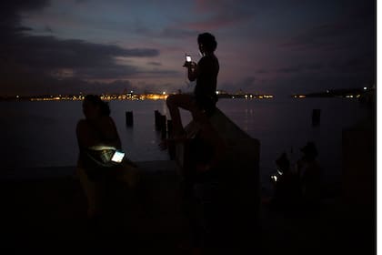 La gente se conecta a Internet en un punto de acceso en Regla, provincia de La Habana
