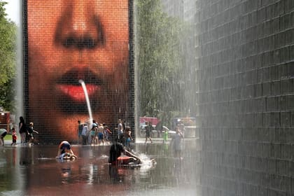 La gente se refresca en Crown Fountain en Millennium Park cuando las temperaturas alcanzaron un récord de 97 grados Fahrenheit el 17 de junio de 2024 en Chicago, Illinois. Se espera que las temperaturas en la ciudad alcancen máximos de 90 grados durante el resto de la semana.