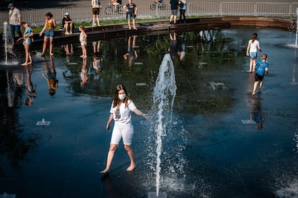 La gente se refresca en una fuente en Moscú, en medio del brote de coronavirus