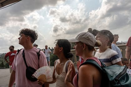 La gente se refresca frente a los rociadores de agua en Piazza Michelangelo en Florence (Francesca Volpi/The New York Times)