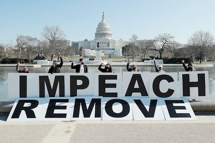 Gente reunida en el Capitolio manifestándose en favor al juicio político contra Trump