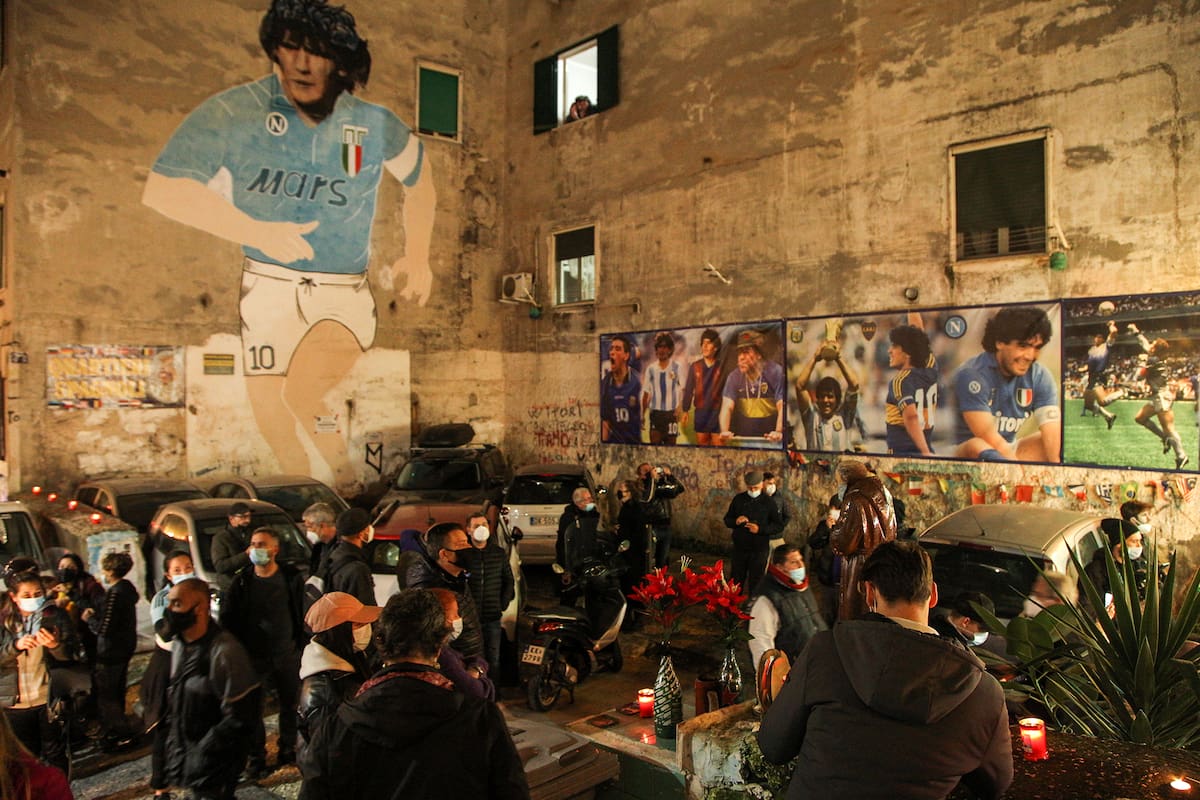 La gente se reúne en la cima del Quartieri Spagnoli en Nápoles el 25 de noviembre de 2020 junto a un mural de 1990 que representa a la leyenda del fútbol argentino Diego Maradona, para llorar después del anuncio de la muerte de Maradona