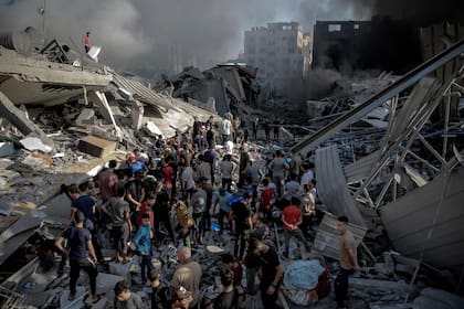 La gente se reúne en medio de la destrucción tras un ataque israelí a la ciudad de Gaza