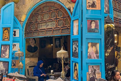 La gente se sienta en el café Umm Kulthum, que lleva el nombre de la fallecida cantante, compositora y actriz de cine egipcia, en la zona histórica de Khan al-Khalili, en el corazón de la capital egipcia, El Cairo, el 28 de enero, antes del 50º aniversario de su muerte