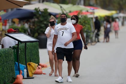 La gente usa máscaras a lo largo de Miami Beach, el famoso Ocean Drive de South Beach, el lunes 22 de junio de 2020. Más de 100,000 personas en Florida han sido diagnosticadas con el coronavirus.