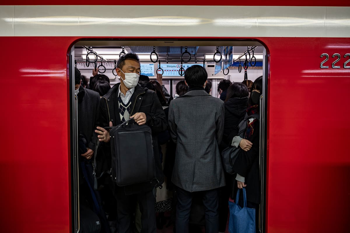 La gente viaja con tapabocas en un tren desde la estación de Shinjuku durante la hora pico de la mañana en Tokio el 4 de enero de 2021