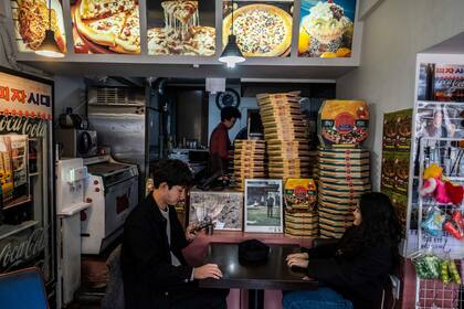 La gente visita Sky Pizza, un restaurante en Seúl, Corea del Sur que aparece en la película "Parásito"