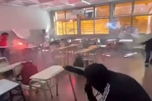Un grupo de alumnos realiza una ”guerra de bengalas" dentro de un aula