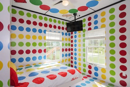 La habitación del Twister tiene el tablero en el techo y la alfombra en las paredes y ropa de cama
