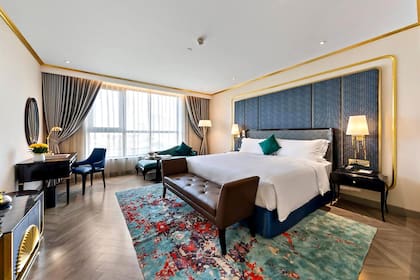 La habitación doble está decorada con detalles dorados, muebles elegantes y una bañera bañada en oro