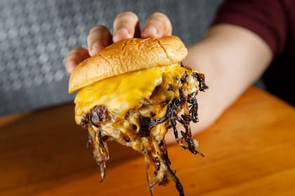La hamburguesa Oklahoma de TFTS se cocina junto a la cebolla en la plancha.