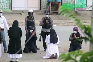 La hermana Ann Rose Nu Tawng arrodillada ante los policías para proteger a los jóvenes manifestantes que buscaron refugio dentro de su clínica