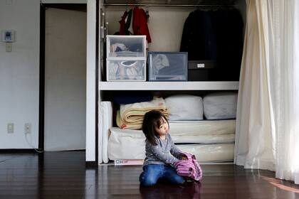 la hija de 3 años de Naoki Numahata juega en el living de su departamento de Tokio