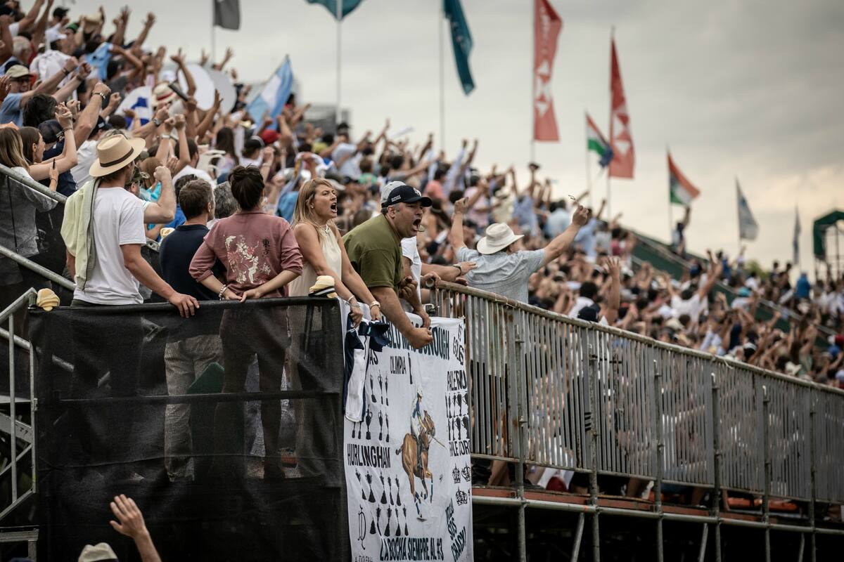 La hinchada de La Dolfina exulta por la conquista número 13 del club en el Argentino Abierto y por el nuevo triunfo de Adolfo Cambiaso; una bandera detalla los logros del crack.