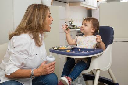 La hora del almuerzo. En la cocina de su departamento, Silvia posa con Elisa, fruto del matrimonio de su hijo Justo Benetti con Isabel Tassara.