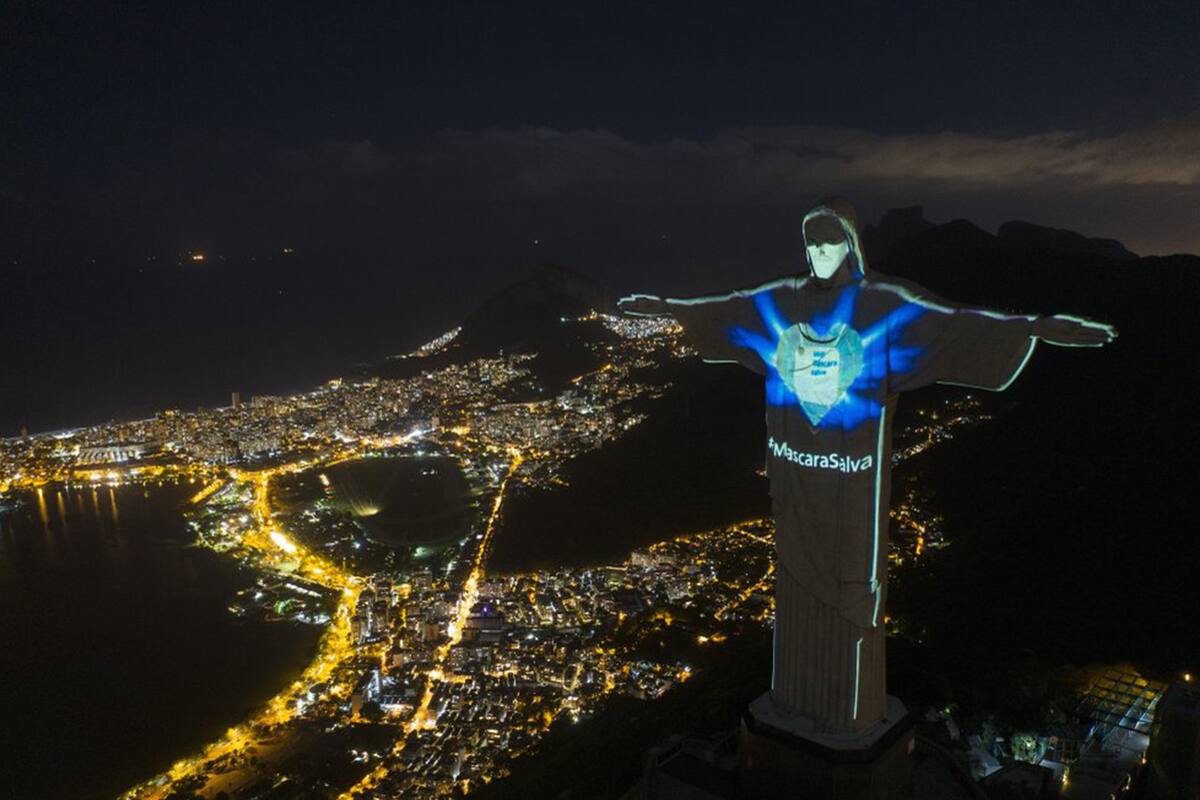 La icónica estatua del Cristo Redentor iluminada como si llevase una mascarilla y con la frase "Mascarillas salvan" (en portugués), durante la pandemia del coronavirus, en Río de Janeiro