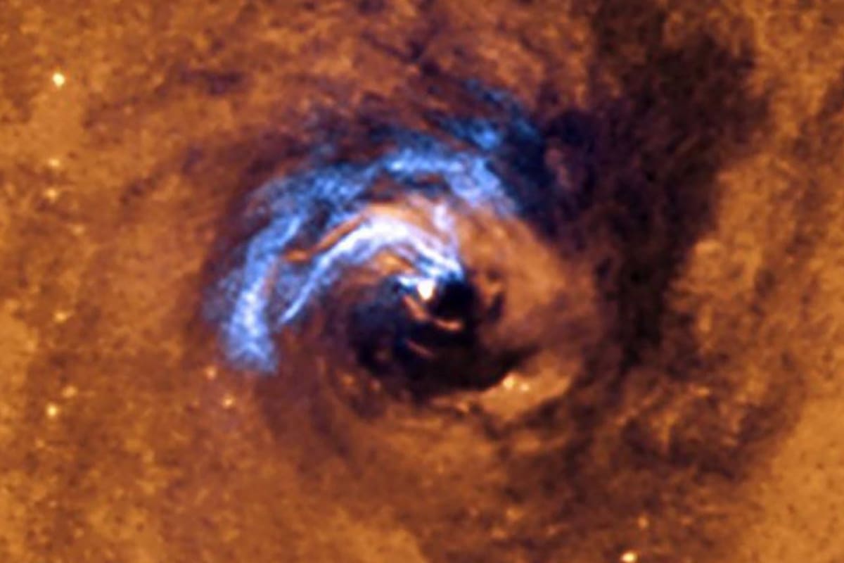 La imagen muestra el proceso de alimentación nuclear de un agujero negro en la galaxia NGC 1566, y cómo los filamentos de polvo, que rodean al núcleo activo, quedan atrapados y giran en espiral alrededor del agujero negro hasta que se los traga