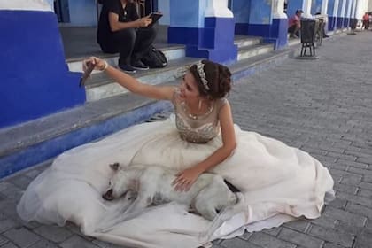 La joven que realizaba la sesión de fotos se tomó con humor la situación y posó junto al perro (Twitter)