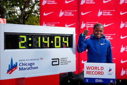 La keniata Brigid Kosgei posa con la nueva plusmarca que estableció para la maratón femenina