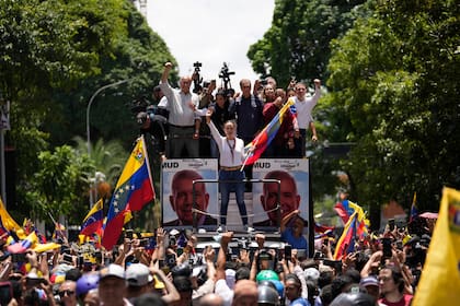 La líder opositora María Corina Machado sostiene una bandera nacional mientras saluda a sus partidarios a su llegada a un mitin en Caracas, Venezuela, el sábado 3 de agosto de 2024.