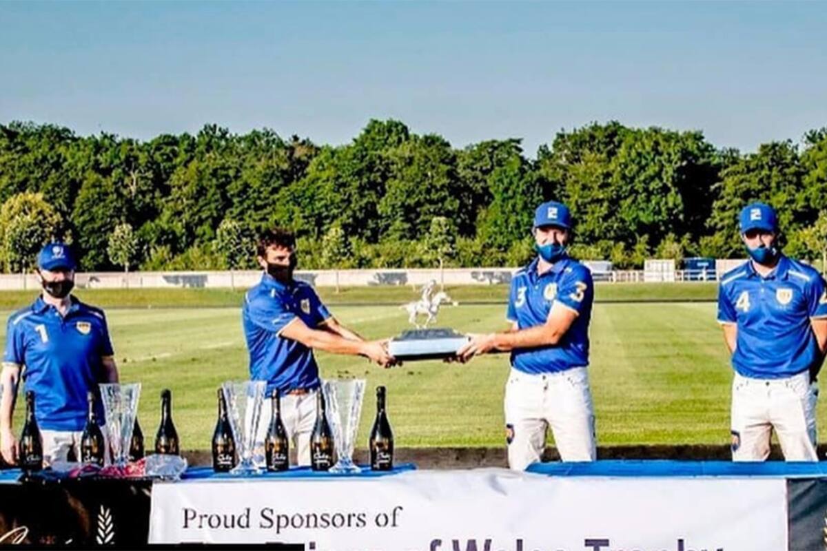 La llamativa premiación tras el primer torneo de la temporada alta británica: Kian Hall y Gonzalo Pieres (h.) parecen tironear por el trofeo Príncipe de Gales, pero en realidad están manteniendo la distancia social; junto a ellos, el patrón Andrey Borodin y Facundo Pieres, de Park Place.