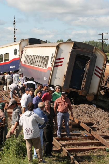 La locomotora y los primeros vagones del tren de Ferrobaires descarrillados luego de embestir al ómnibus de El Rápido Argentino
