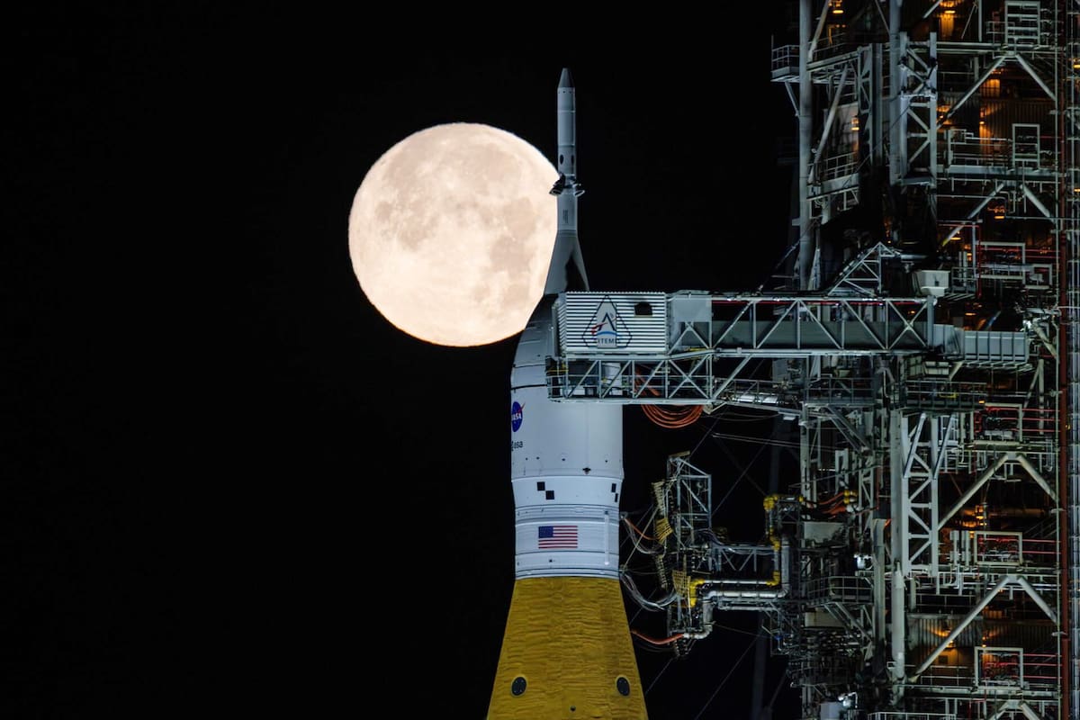 La Luna llena se ve sobre la nave Orion en el Sistema de Lanzamiento Espacia en la plataforma del Centro Espacial Kennedy en Florida