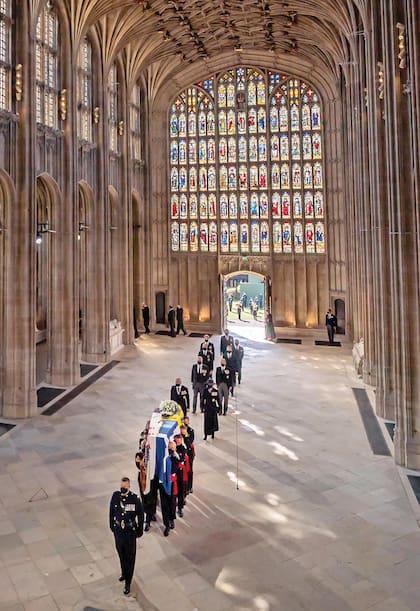 La luz del sol de primavera ilumina la ventana
oeste y la nave central de la capilla cuando
entra el ataúd del duque, seguido por miembros
de la familia real, que se sientan en grupos
socialmente distanciados a ambos lados