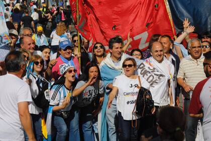 Con banderas celestes y blancas y carteles con leyendas en apoyo al presidente, grupos de manifestantes, en familia o en grupos de amigos, llegaban a la avenida 9 de Julio