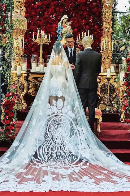La mayor de las hermanas KardashianJenner sorprendió con un vestido mini de Dolce Gabbana, al que le sumó un larguísimo velo con la imagen de la Virgen María y las palabras “familia”, “lealtad” y “respeto”, bordadas en punto cruz. Son un guiño a los tatuajes que su marido tiene en la cabeza.