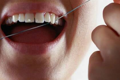 Para prevenir las caries se deben cepillar los dientes tres veces al día, y usar el hilo dental durante la noche