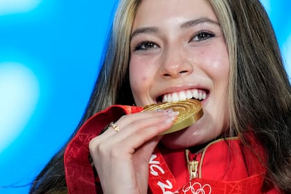 La medallista de oro Eileen Gu, quien representa a China, celebra tras recibir la presea en el podio tras ganar en el debut del freeski big air en los Juegos Olímpicos de Beijing el martes 8 de febrero del 2022. (AP Foto/Natacha Pisarenko)