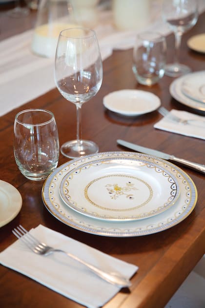 La mesa, cancherísima y descontracturada, con cubiertos antiguos, platos de la marca de Juliana y platos de pan, todos distintos.