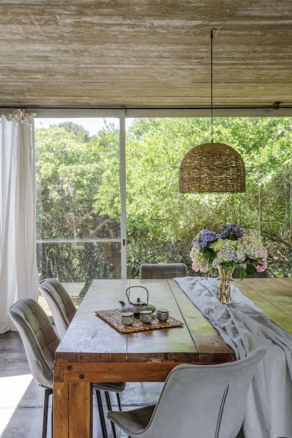 La mesa de comedor interior se hizo a medida, para celebrar reuniones grandes. En ninguna ventana se pierden de vista las copas de los árboles.