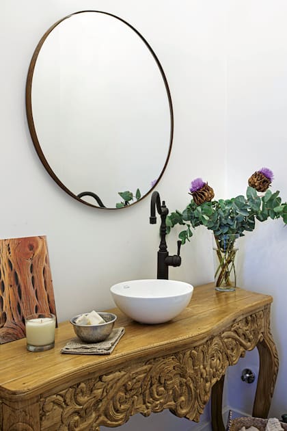 La mesa de estilo comprada en un anticuario sirve como apoyo para la bacha (Ferrum), en este toilette, grifería monocomando ‘Satis’ negra (Agata Faucets), espejo ‘Soho’ (Manjatan).