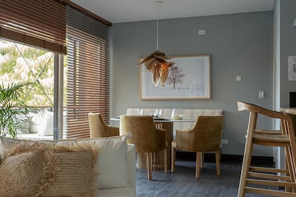 La mesa ovalada tiene una tapa fina de Dekton ‘Rem’ (Canteras del Mundo) trabajada por Marmolería Forte. Cortinas horizontales de madera de Hunter Douglas (Revestir S.A.).