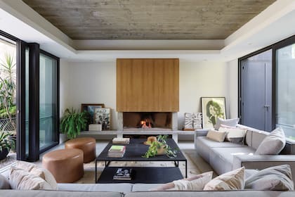 La mesa ratona se hizo a medida sobre un diseño de César Lago, dueño de casa y de @lago_project. Aberturas (Next Windows). Sillones y banquetas de cuero (Impronta Sillones). La chimenea se revisitó en petiribí.
