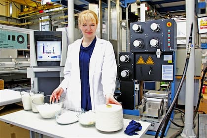 La microbióloga Anke Domaske en su laboratorio, con telas y fibras confeccionadas con leche desechada
