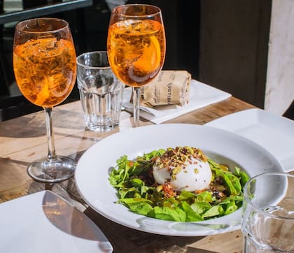 La miel es el toque característico de la burrata sobre rúcula de Il Qotidiano