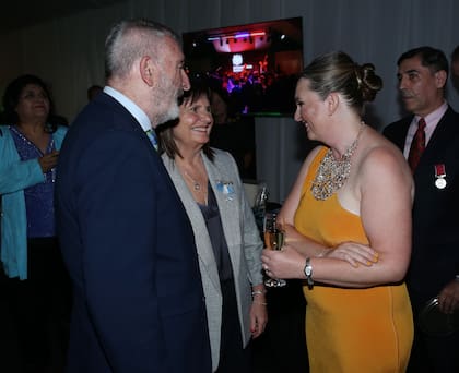 La ministra de Seguridad, Patricia Bullrich, y su esposo, Guillermo Yanco, saludan a la embajadora Kirsty Hayes