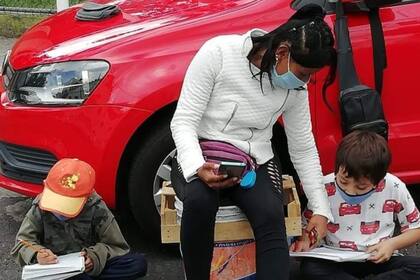 La mujer trabaja como cuidacoches en un barrio de la ciudad de México DF y aprovecha el servicio gratuito de internet en esa zona para poder seguir de cerca la experiencia escolar de sus hijos en tiempos de pandemia