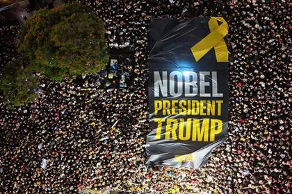 La multitud reunida en la Plaza de los Rehenes despliega un inmenso cartel dando gracias a Trump. Foto: Uriel Even Sapir.