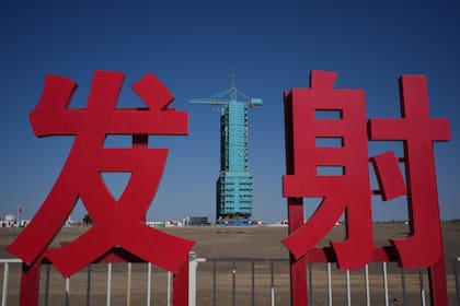 La nave Shenzhou-21 se ve sobre un cohete Long March en una plataforma de lanzamiento cerca de los caracteres chinos para lanzamiento, en el Centro de Lanzamiento de Satélites en el noroeste de China, el jueves 30 de octubre de 2025. (AP Foto/Andy Wong)