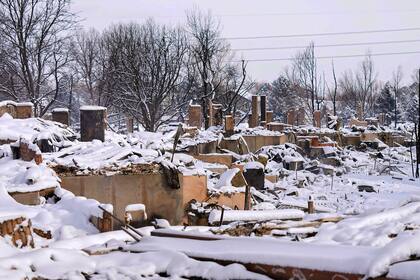 La nieve cubre los restos de viviendas destruidas por un incendio forestal en Mulberry Street, el sábado 1 de enero de 2022, en Louisville, Colorado. (AP Foto/Jack Dempsey)