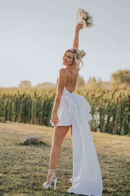 La novia eligió un vestido
mini con finos breteles y un
gran moño en la parte trasera
a la altura de la cintura, de Márian Saud.